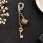 Apagavela Llave decorativo con acabado dorado